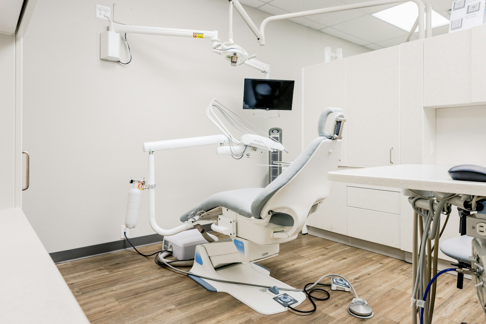 White dental chair and overhead light in a clean minimalist operatory